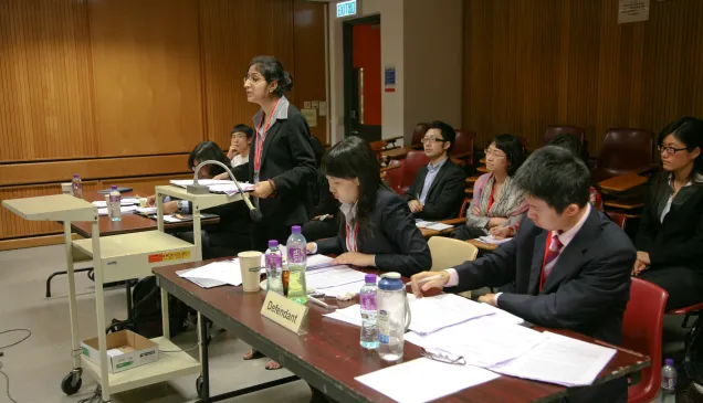 在法官面前,法律系3年级的学生加里玛•米特拉代表希达亚图拉国立法律大学与来自中国国际关系学院的同学们进行辩论。