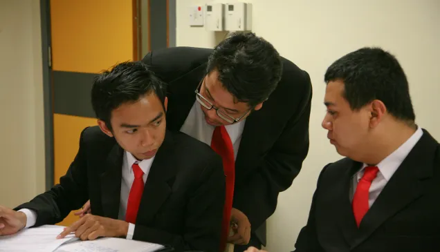 在2011年亚太地区国际人道法模拟法庭比赛中,来自加札马达大学的里兹基•维拉特托洛(左)与他的队员就案例进行讨论。