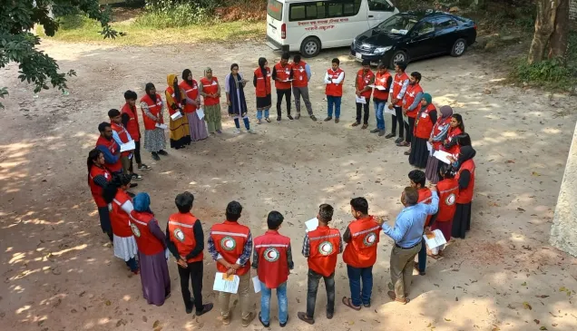 ICRC staff standing facing each other in a circle with picture taken from above