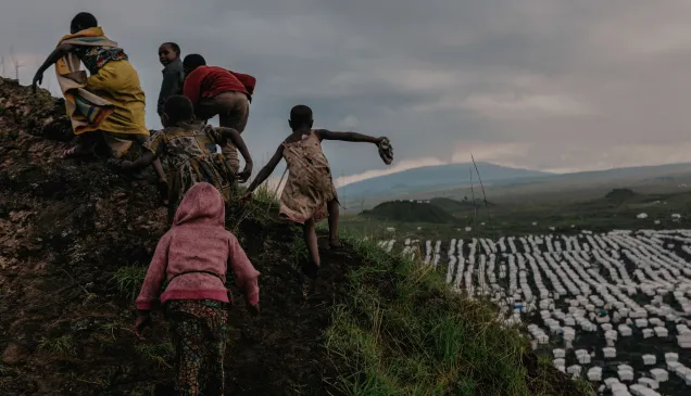 Los niños escalan las laderas del cráter de un volcán extinto sobre el campamento de Lushagala