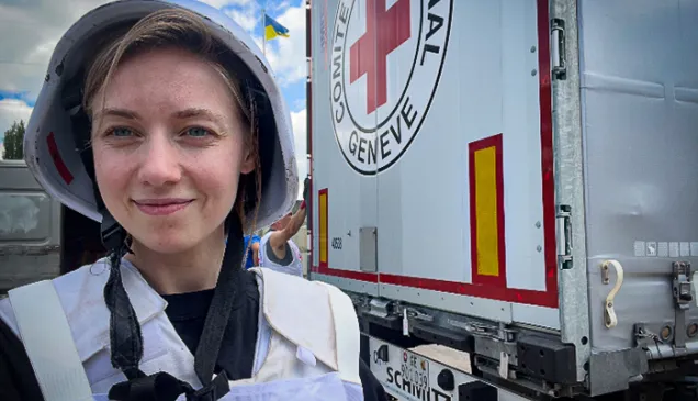An ICRC worker standing in front of a marked truck