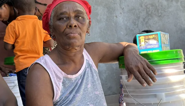 Una mujer en Haití con elementos de primera necesidad.