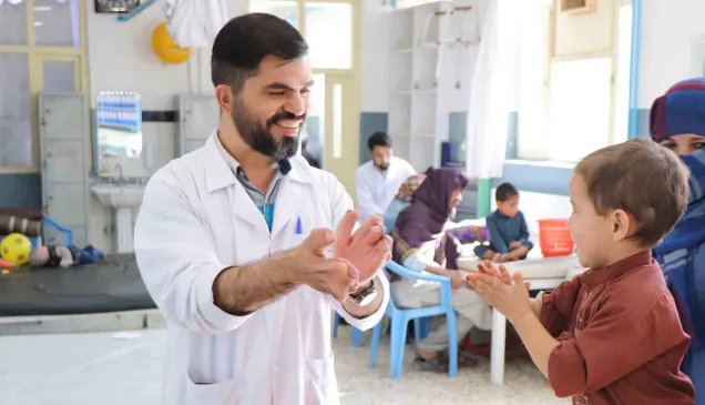 An ICRC staff playing with a child suffering from Cerebral Palsy at the ICRC's physical rehabilitation centre in Kabul