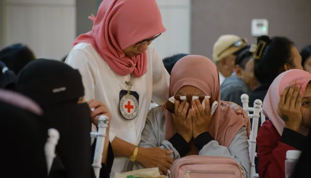ICRC protection field officer Raidah Latip comforts the family member of a person who went missing during the Marawi conflict