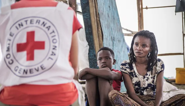 Sylvie Zawadi Miranyo, a mother of four now living in Musenyi camp in Giharo commune, southern Burundi, sits on a mat in the tent where she has been staying, her son beside her, speaking to an ICRC staff member. Sylvie Zawadi Miranyo, a mother of four now living in Musenyi camp in Giharo commune, southern Burundi, sits on a mat in the tent where she has been staying, her son beside her, speaking to an ICRC staff member.
