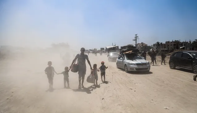 A father with his 4 children walking in an area full of sand