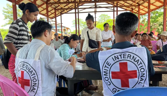 Two ICRC staff assisting people in Myanmar