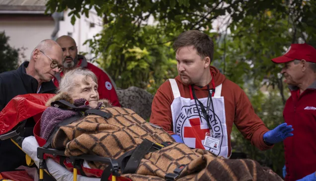 Mykolaiv. An ICRC staff member is talking to an old lady while she is being transferred to a new specialized facility.