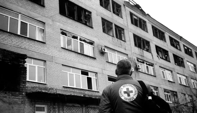 An ICRC staff member observes the wreckage of a damaged hospital in Petropavlivka, Ukraine. 