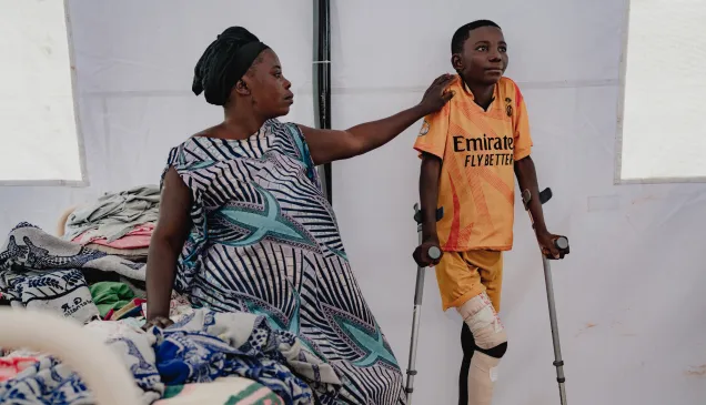 Adela Yang and her son Ebwela Liko at Fizi general hospital.  Adela’s son is 14 years old, and was hit by a bullet in the leg whilst he was sheltering at home from fighting in his home village of Kaguli. “We were hiding at home, but he stood up to run away, and so was hurt by a bullet. Others in the village, including his teacher came and helped carry him to the health centre. It was 5 kilometres away. We stayed there for 1 week while they stabilised him. A CICR ambulance brought him to the