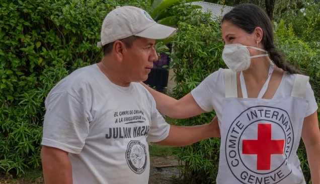 Una persona del CICR y una persona de una comunidad hablando