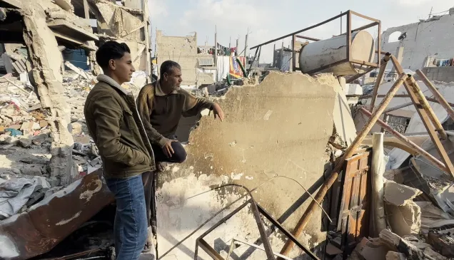 Iyad Wahidi, 53, sits on the ruins of his destroyed home in Jabalia, near the yellow line, where some families live in difficult conditions, with limited access to essential services, including water, sanitation, healthcare, and education.
