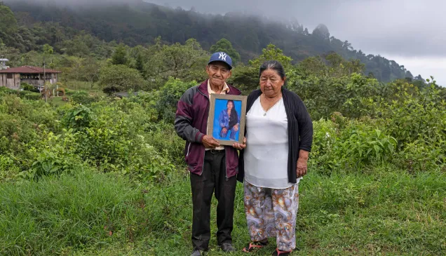 Un hombre y una mujer sostienen la fotografía de un familiar desaparecido.