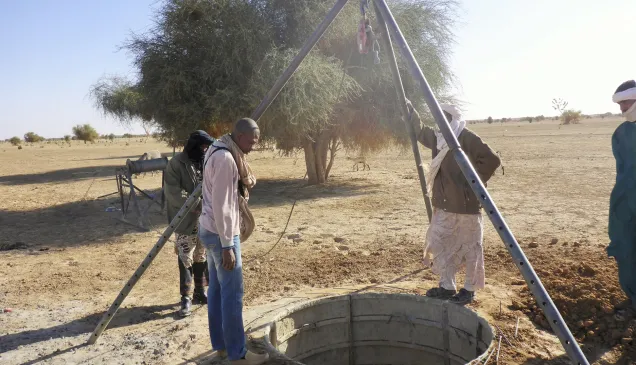 Ghataye. Des hommes observent les travaux de fonçage d'un puits.