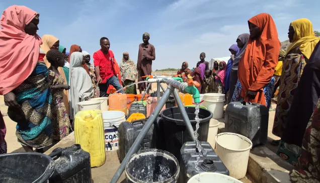 Community water point with community members fetching water