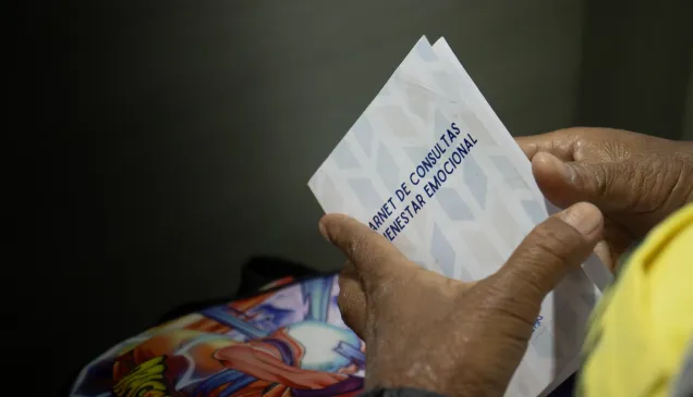 Una paciente sostiene en sus manos una tarjeta de control de citas de bienestar emocional