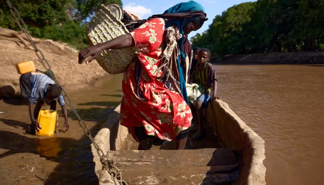 A woman navigates her seat in a boat in Somalia.