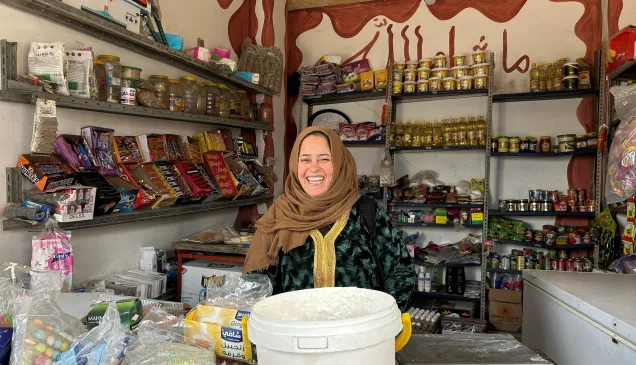 Nadwa sits in her shop, smiling at the camera