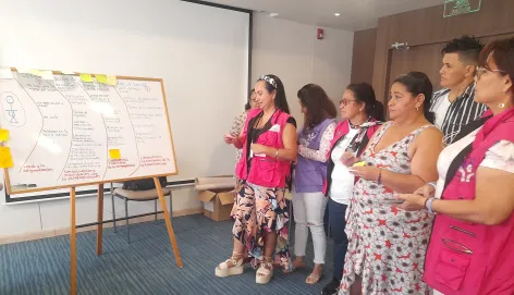 Women in a room looking at a whiteboard