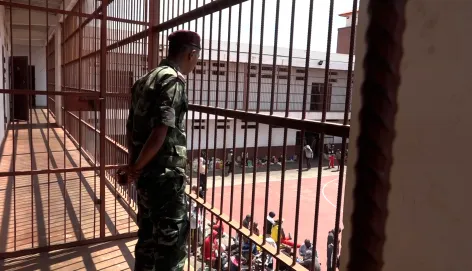 Un homme de dos, en tenue, dans une prison à Madagascar.