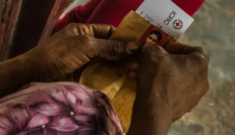 A woman's hands holding a picture of a missing loved one. ICRC