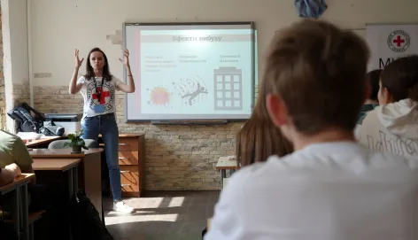 Kyiv, school. An ICRC staff member specializing in weapons contamination holds a risk awareness and safe behaviour session for children.