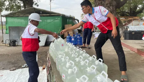 ICRC workers providing clean water containers in Myanmar