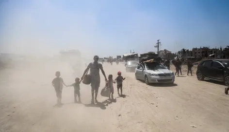 A father with his 4 children walking in an area full of sand
