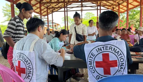 Two ICRC staff assisting people in Myanmar