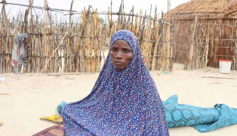 Une femme du projet mamans lumière à Bagasola assise sur une natte