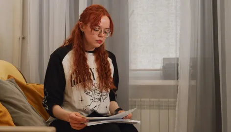 Женщина читает письмо от родственника