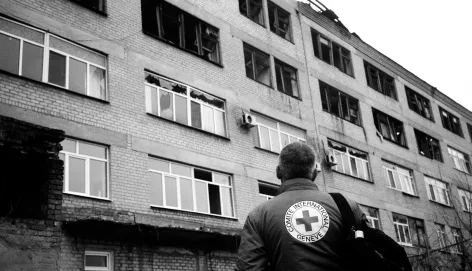 An ICRC staff member observes the wreckage of a damaged hospital in Petropavlivka, Ukraine. 