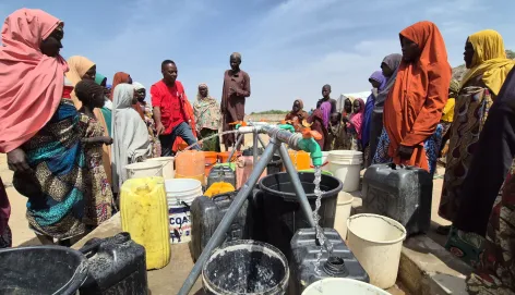 Community water point with community members fetching water