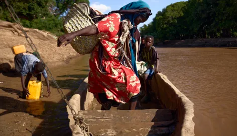 A woman navigates her seat in a boat in Somalia.