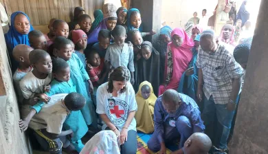 Família é reunida sob o olhar de pessoas da comunidade e de funcionários do CICV