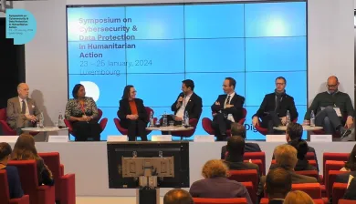 Delegates in a panel, seated in a row at Symposium on Cybersecurity