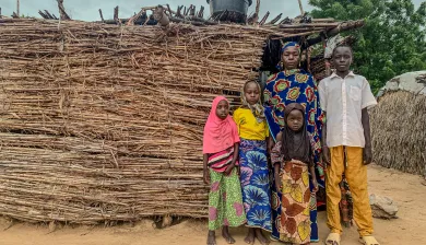 Fana Biri posing in front of her home with her children