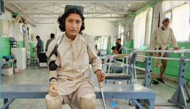 Image of woman with prosthetic legs and arm sitting on a bench in a rehabilitation centre