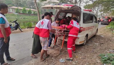 Un equipo de emergencia de la Cruz Roja de Myanmar carga a un herido en una camilla dentro de una ambulancia tras el terremoto de Myanmar, prestando ayuda médica urgente.
