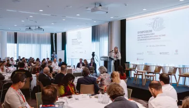 Group of search practioners and experts from various sectors in a conference room with a speaker on the stage