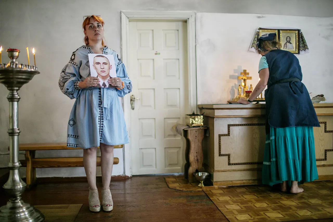 Antonina holds a portrait of her brother Mykola, in the Cathedral of Nativity in Korosten