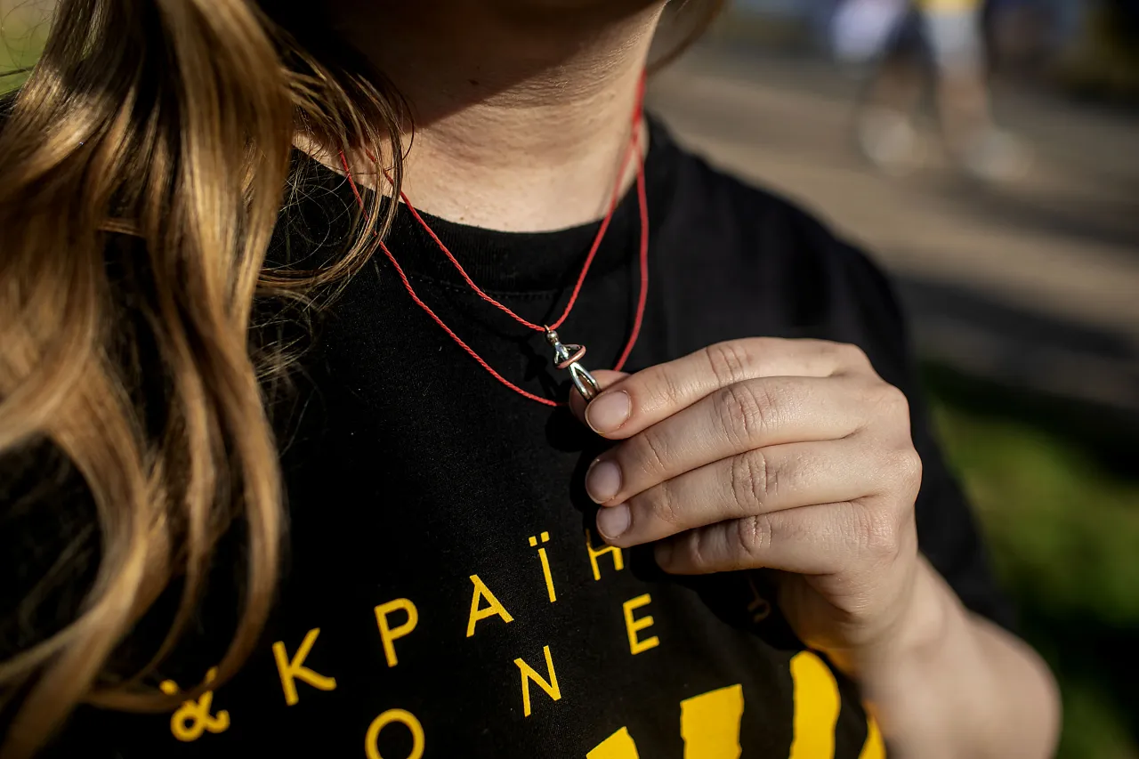 She holds a necklace she wears that has another part with Lyosha, strengthening their bond even in these difficult times. 