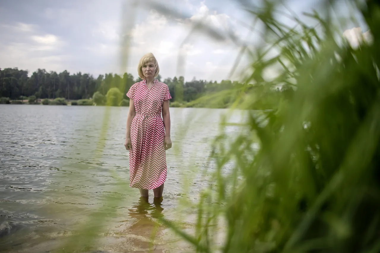 Nina standing by the waters of the Sviatoshynske Lake in Kyiv, reflects on the memories she and Vasyl shared here, a place where they spend time together. 