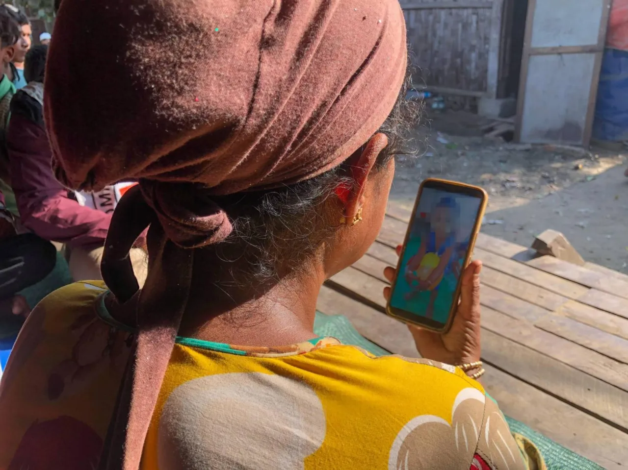 A mother in Rakhine State reconnects with her grandson via a phone call.
