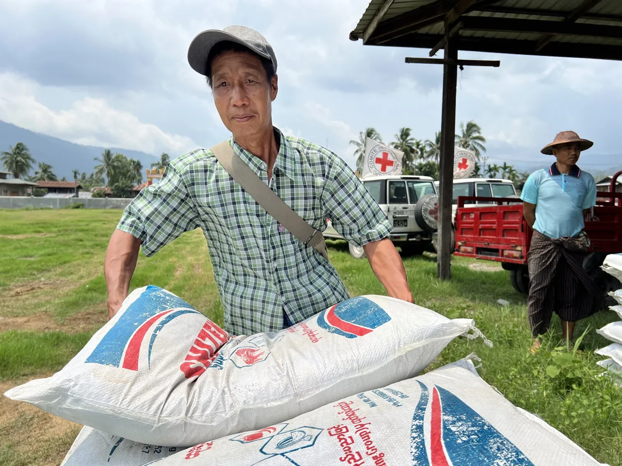 A man carries a sack of agricultural supplies in a distribution from the ICRC in Myanmar. 