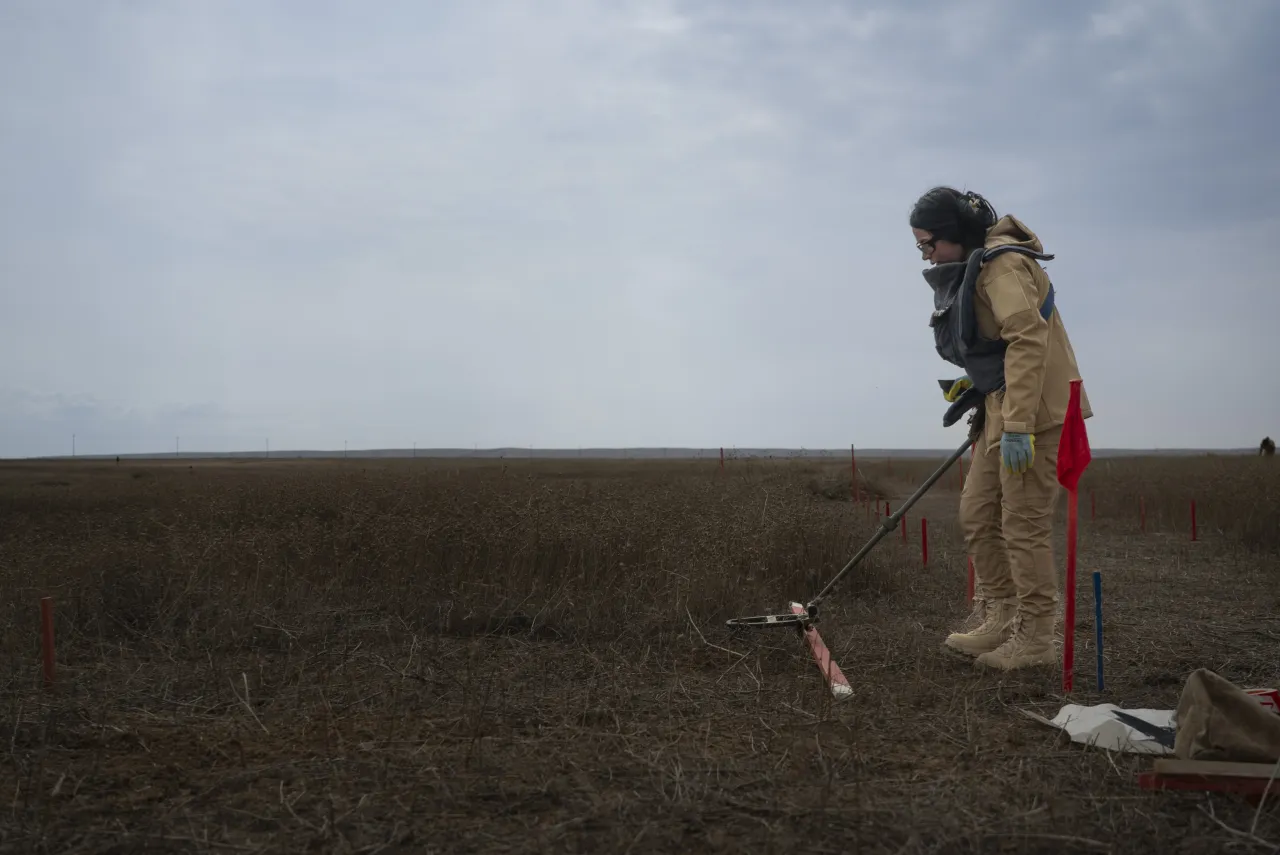 Noora Murad works with a metal detector in a mine field in Iraq. 