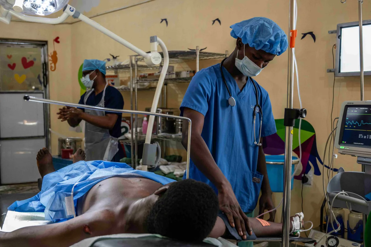 A man injured by an explosive device is prepared for surgery.