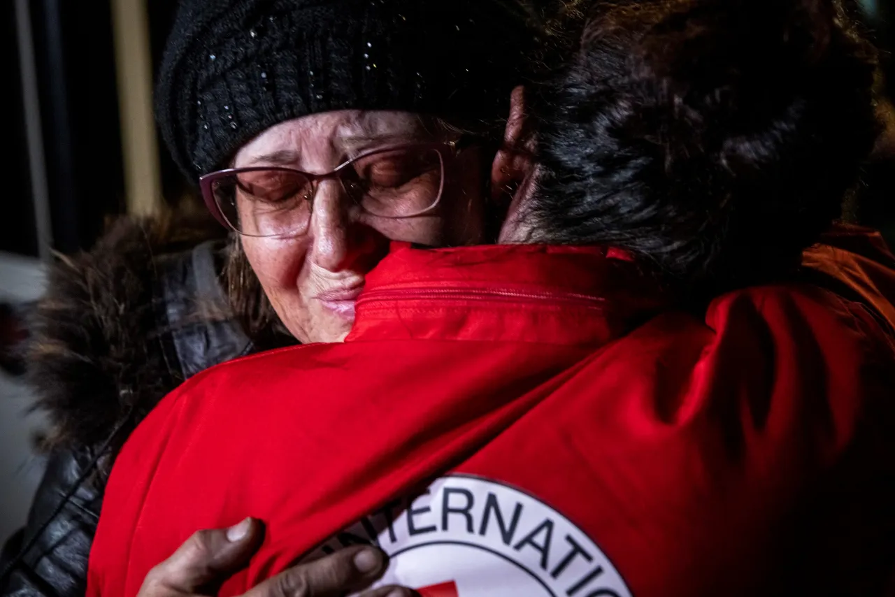 Woamn embraces ICRC worker during evacuation