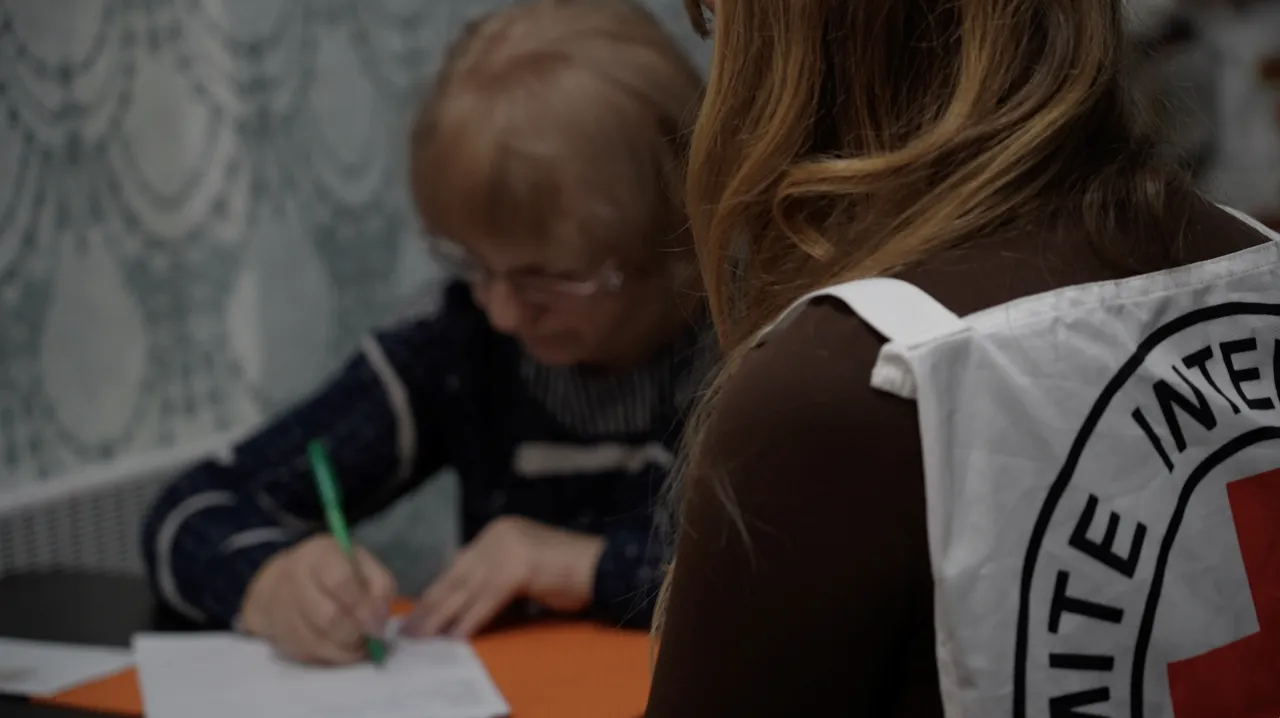Iryna writes a message to be passed on to her son.