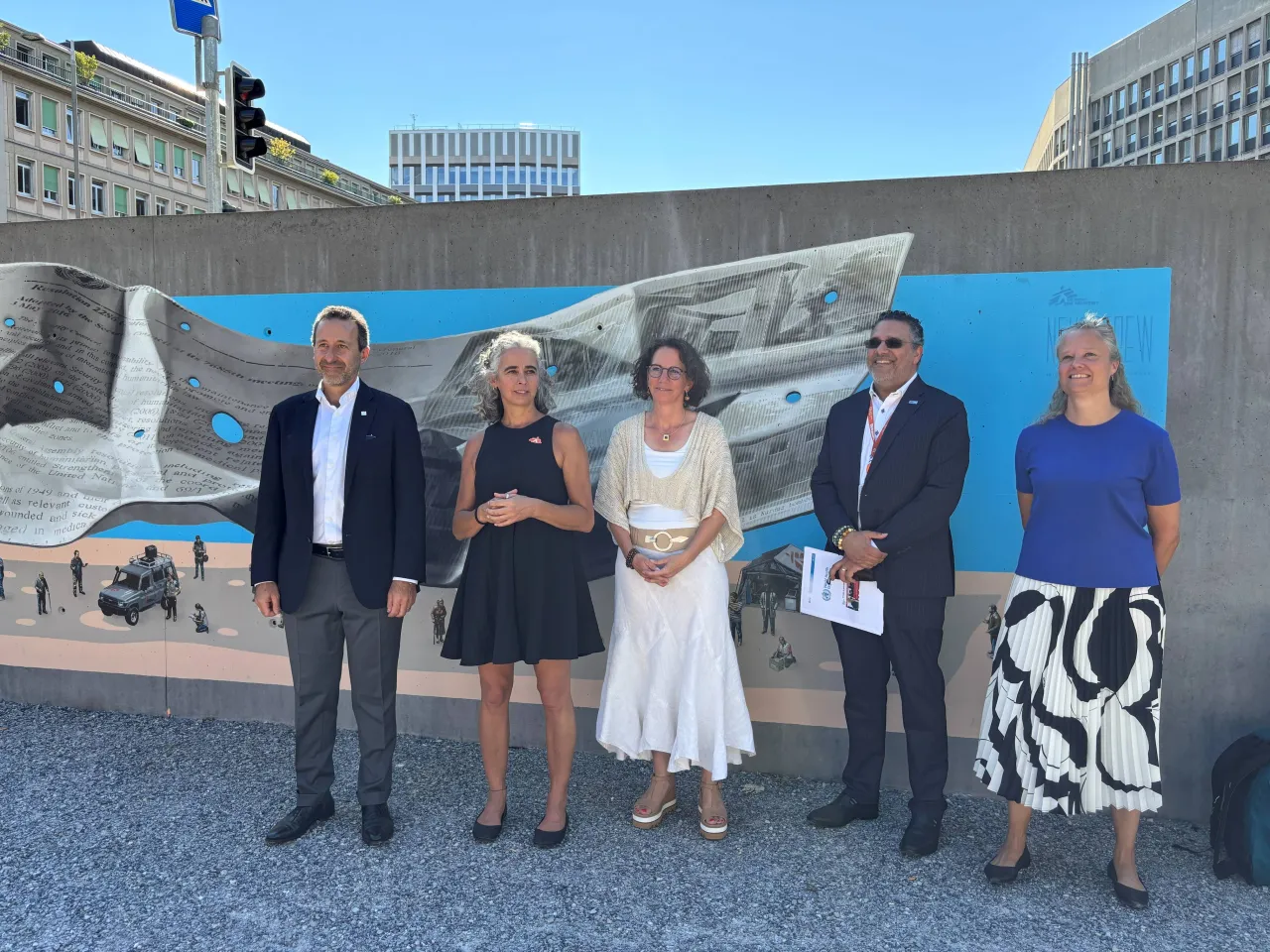 Standing in front of the new mural by Swiss artist duo NEVERCREW, located in front of Geneva University Hospitals (HUG): (R-L) Robert Mardini, Director-General of HUG; Micaela Serafini, President of MSF Switzerland; Yasmine Praz, Director of Operations, ICRC; Altaf Musani, Director, Humanitarian and Disaster Management, WHO; Beatrice Ferrari, Director of International Affairs for the Canton of Geneva